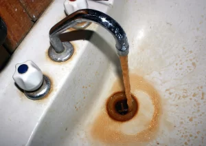 Close-up of rusty water coming from a faucet, plumbing solutions by Trade Pro Plumbing